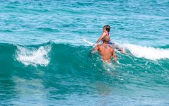 Father teaching his kid to surf on Kata Beach